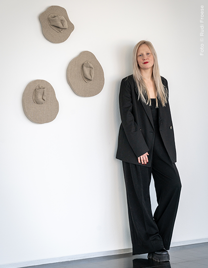 Designerin Joséfina Alanko im schwarzen Anzug bei Studio Visit – Wandinstallation mit textilen Skulpturen