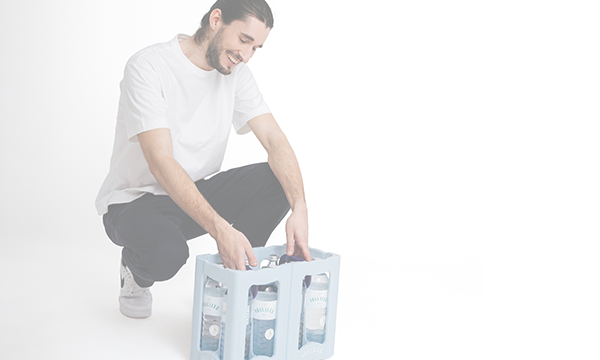 Mann kniet und packt Vöslauer 1l Flaschen aus – Rückgabe und Erstattungsprozess